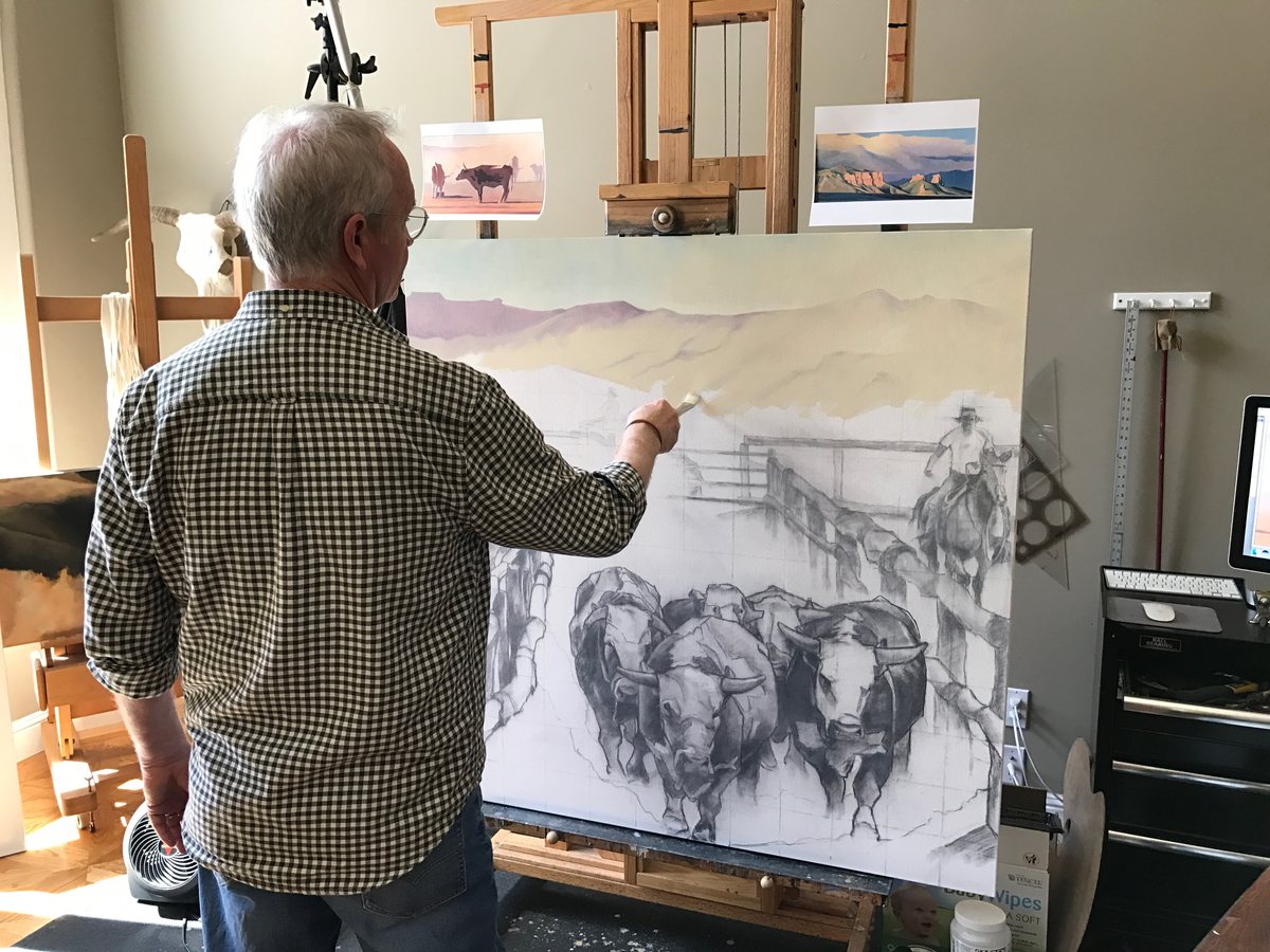 Jerry Scott painting at his easel in the studio, working on a cattle scene